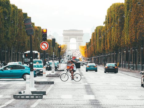 pexels-photo-8667561-8667561 View of busy traffic and cyclist near Arc de Triomphe in Paris on a vibrant day.